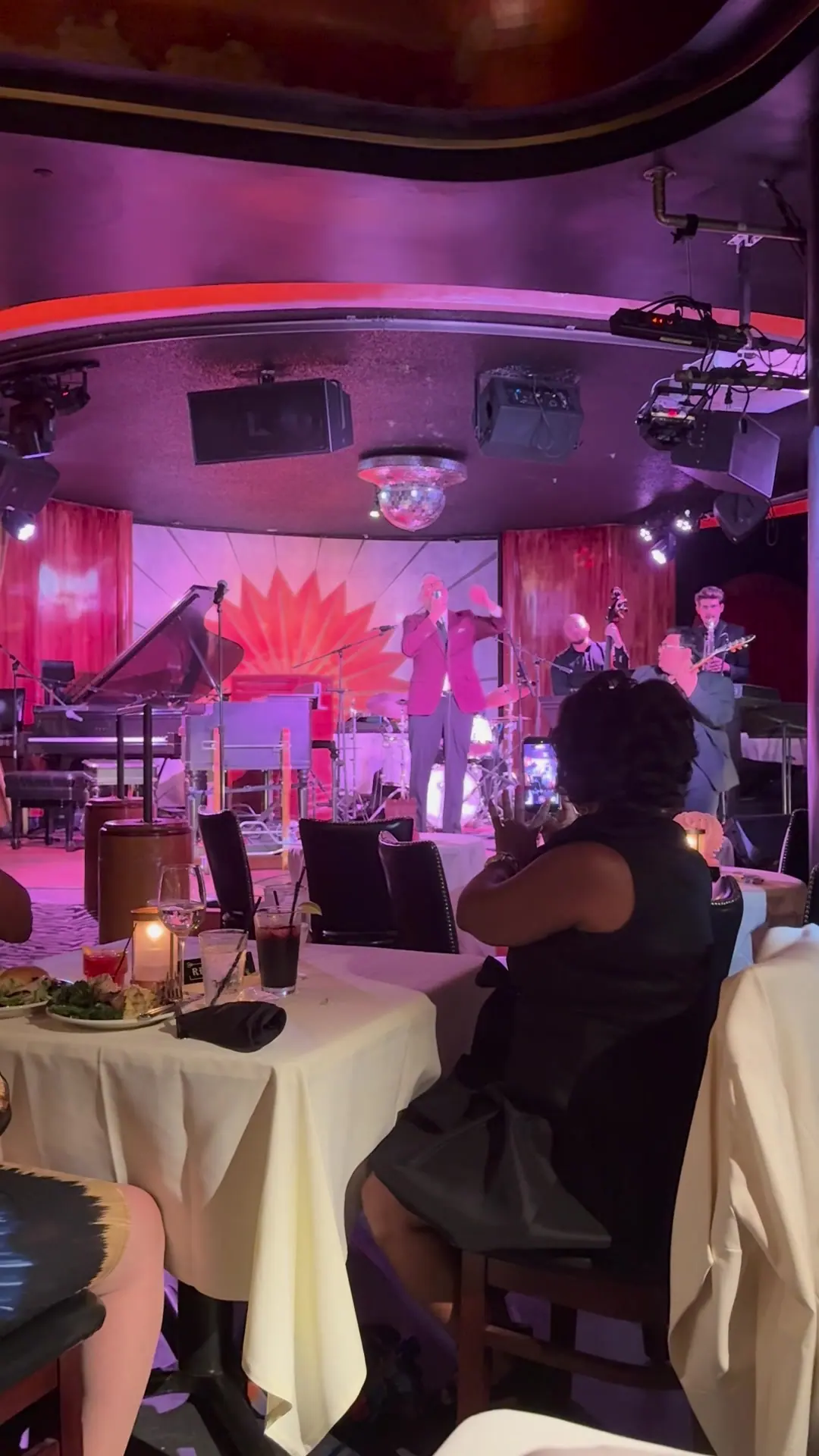 Dinner guests at a candlelit table watch the band from a few feet away